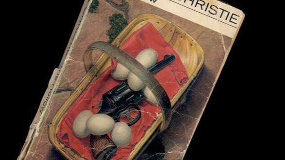 Detailed image of the cover of a paperback book showing an illustration of a gun and eggs in a basket
