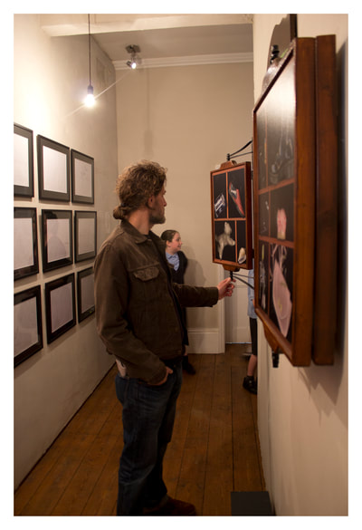 Man looking at the artwork and adjusting a panel.  