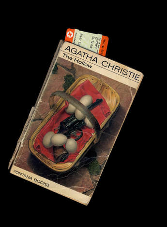 Image of book cover against black background, with train ticket as bookmark