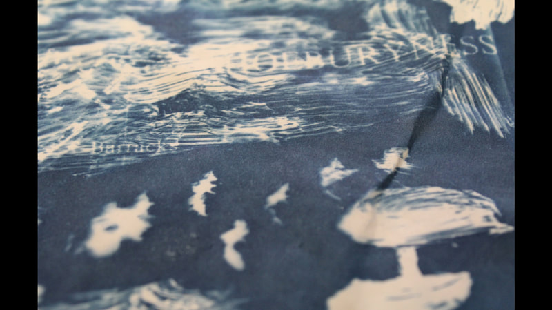 Cyanotype image with white textures, letters and shapes against a dark blue background.