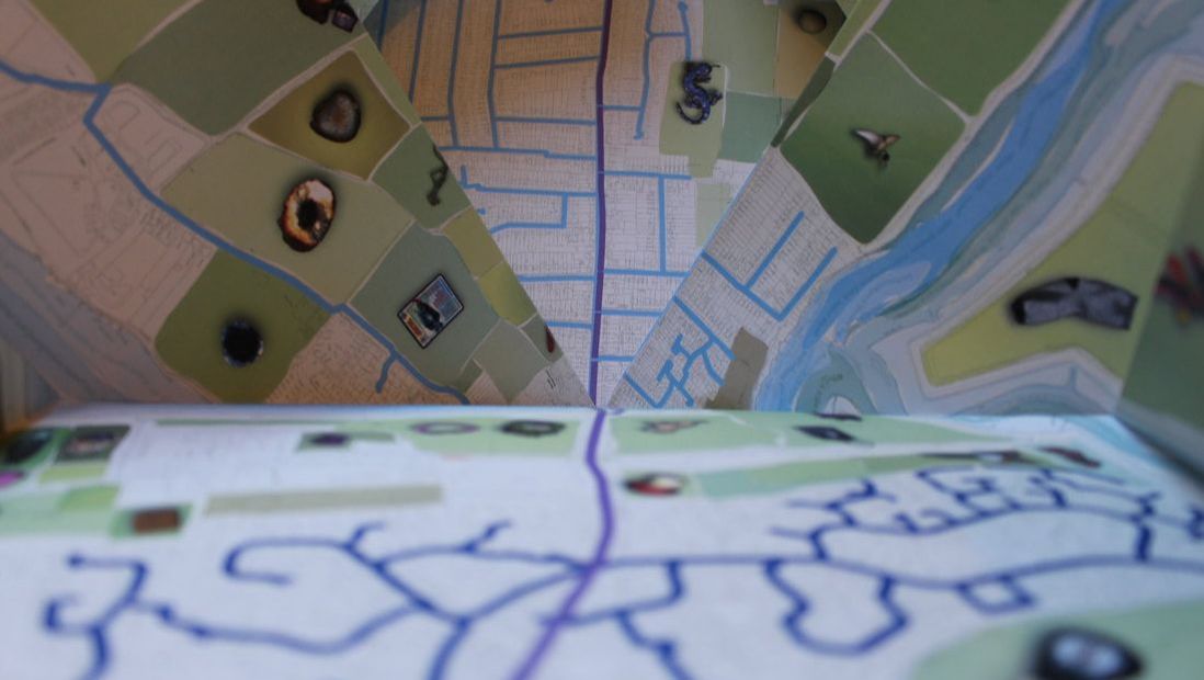 Photo of a folded, hand drawn map, incorporating small photographs 