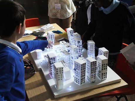 Children playing with paper tower blocks and lights